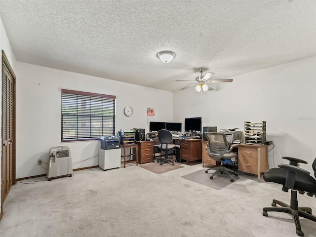 carpeted office space featuring a textured ceiling and ceiling fan