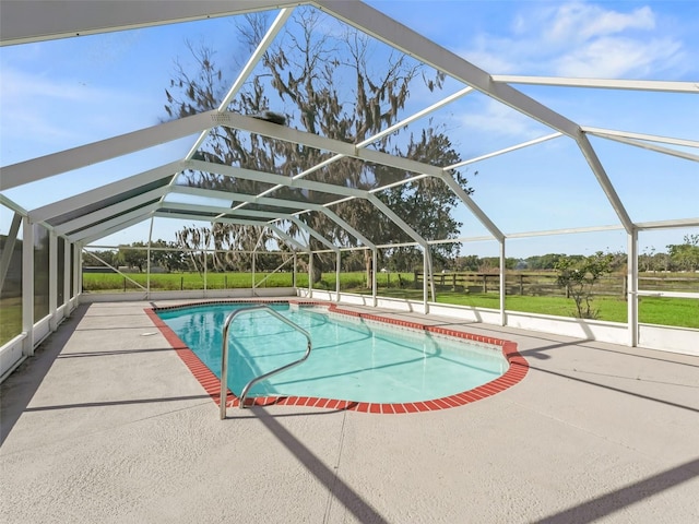 view of swimming pool with glass enclosure and a patio area