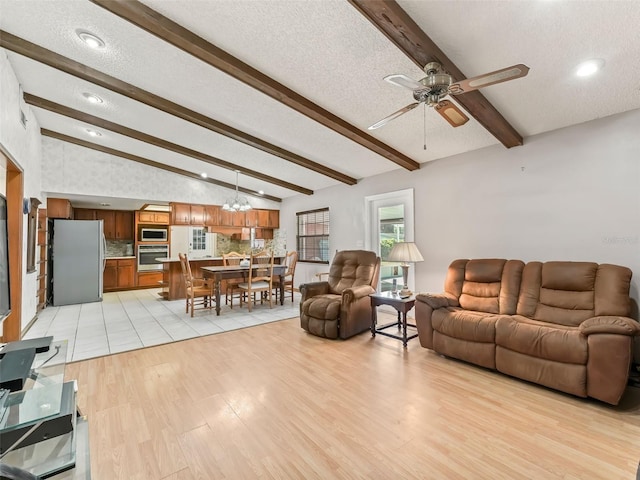 living room with light tile flooring, ceiling fan with notable chandelier, a textured ceiling, and lofted ceiling with beams