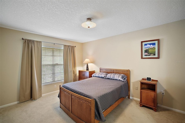 bedroom featuring a textured ceiling and light colored carpet