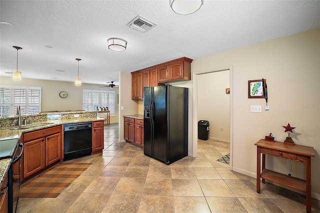 kitchen featuring sink, black appliances, light tile floors, and light stone countertops