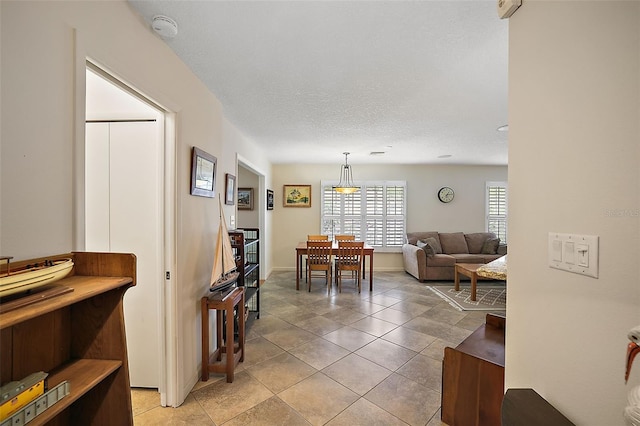 living room with a textured ceiling and light tile patterned flooring