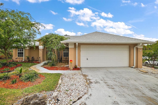 view of front of property featuring driveway, a shingled roof, a garage, and stucco siding