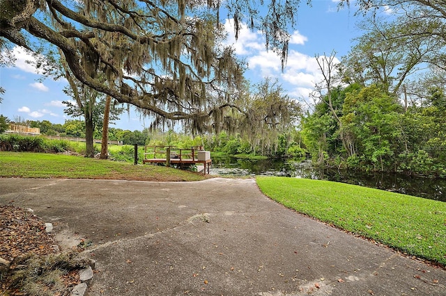 view of community featuring a yard and a water view