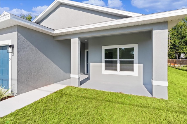 property entrance with a lawn