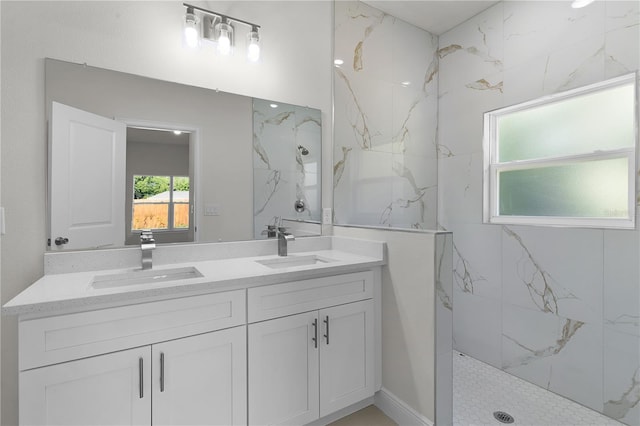 bathroom with double vanity and tiled shower