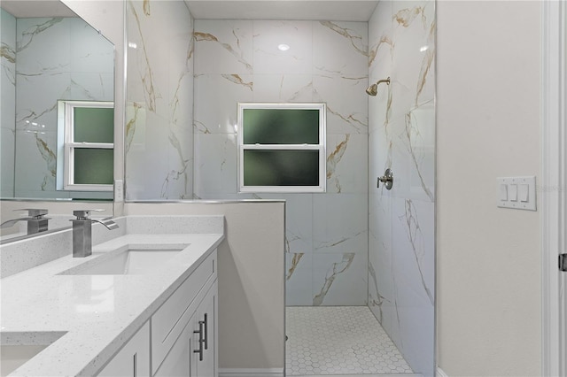 bathroom featuring a tile shower and double sink vanity