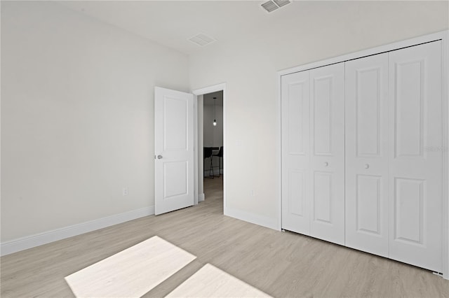 unfurnished bedroom featuring a closet and light wood-type flooring