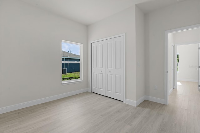 unfurnished bedroom with light wood-type flooring and a closet