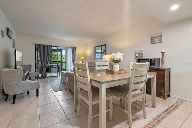 tiled dining area featuring a textured ceiling