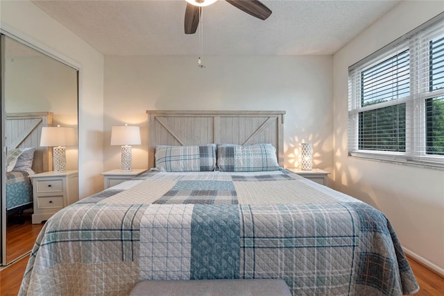 bedroom with a closet, a textured ceiling, ceiling fan, and light hardwood / wood-style flooring