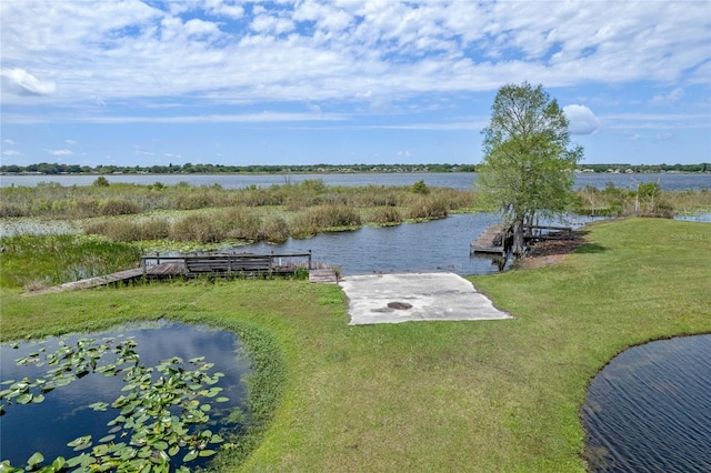 view of dock featuring a water view and a yard