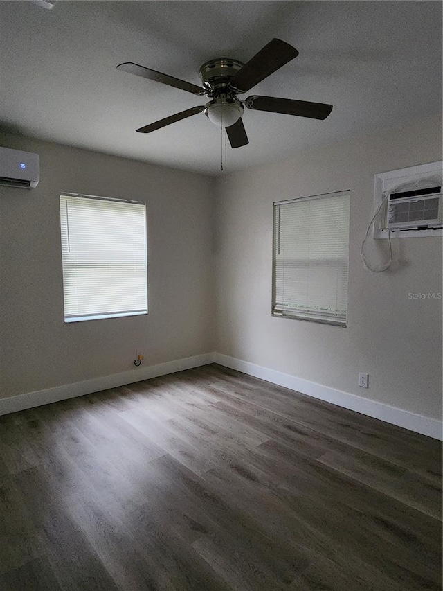 empty room with dark hardwood / wood-style flooring, ceiling fan, and a wall mounted air conditioner