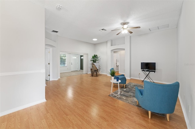 sitting room featuring ceiling fan, wood-type flooring, and a textured ceiling