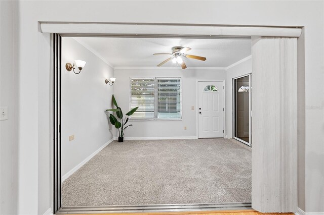 interior space with ceiling fan and crown molding