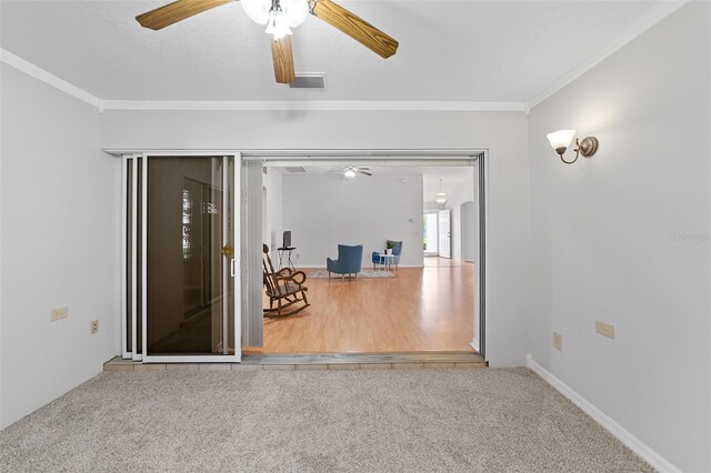 carpeted spare room with ceiling fan and ornamental molding