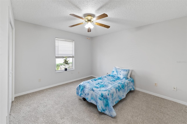 carpeted bedroom with ceiling fan and a textured ceiling