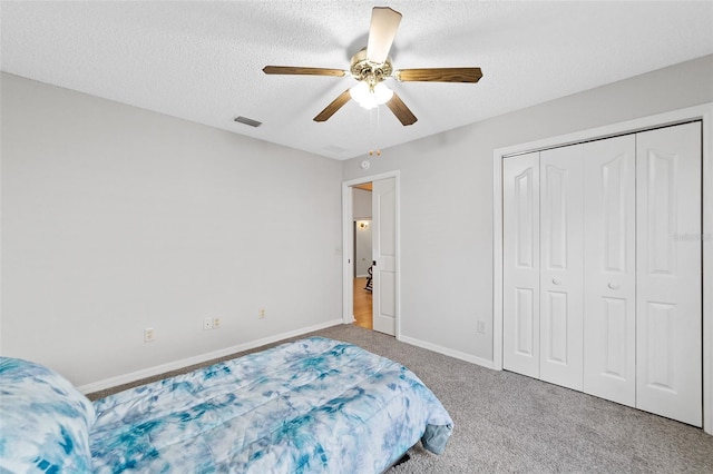 bedroom with ceiling fan, a closet, carpet floors, and a textured ceiling