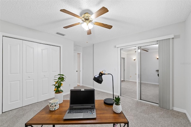 home office featuring carpet floors and a textured ceiling