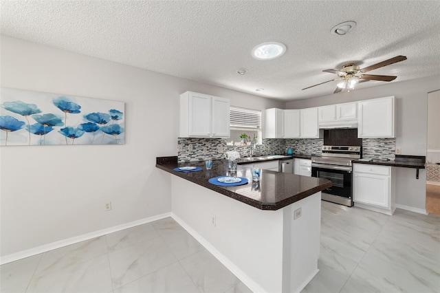 kitchen featuring kitchen peninsula, white cabinets, appliances with stainless steel finishes, and a textured ceiling