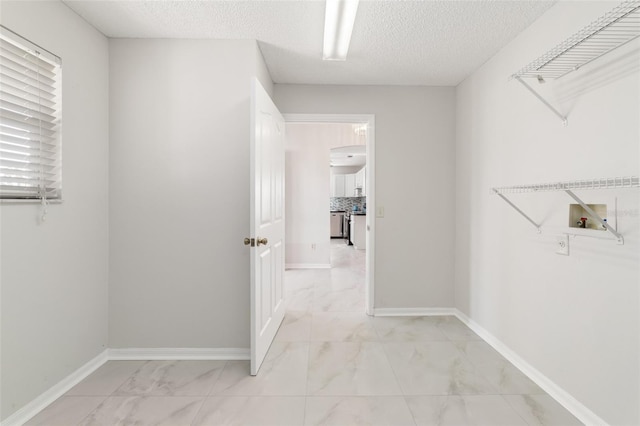 hall featuring a textured ceiling