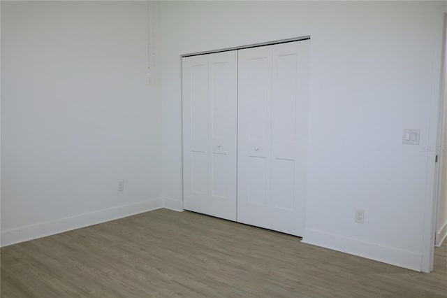 unfurnished bedroom featuring light hardwood / wood-style floors and a closet