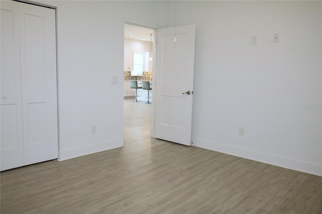 unfurnished bedroom with a closet and light wood-type flooring