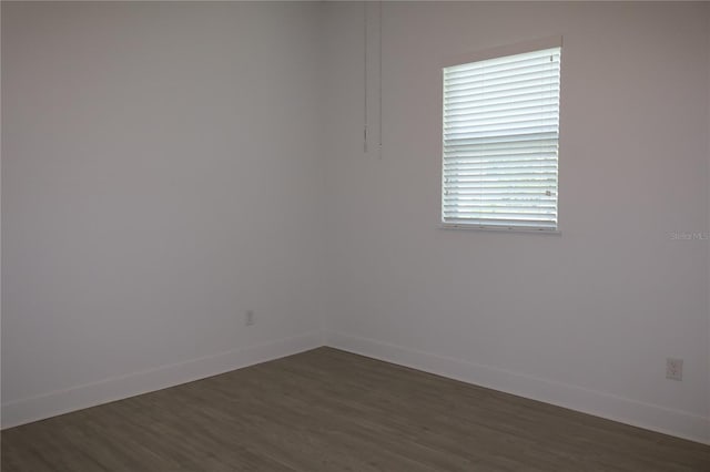 unfurnished room with dark hardwood / wood-style flooring