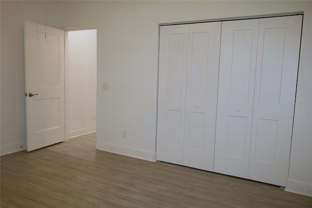 unfurnished bedroom featuring a closet and light hardwood / wood-style floors