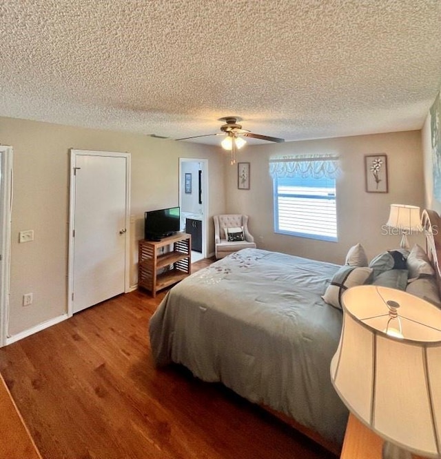 bedroom with a textured ceiling, ceiling fan, and wood-type flooring