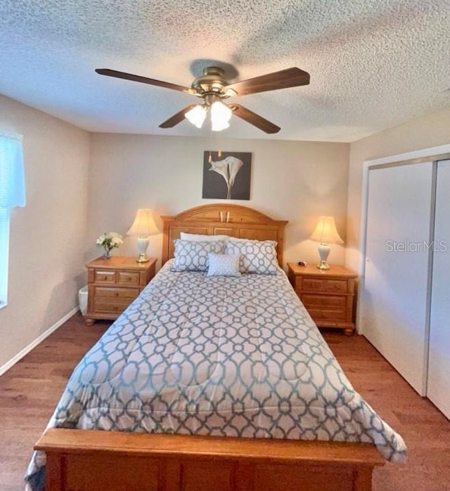 bedroom featuring hardwood / wood-style floors, a textured ceiling, and ceiling fan