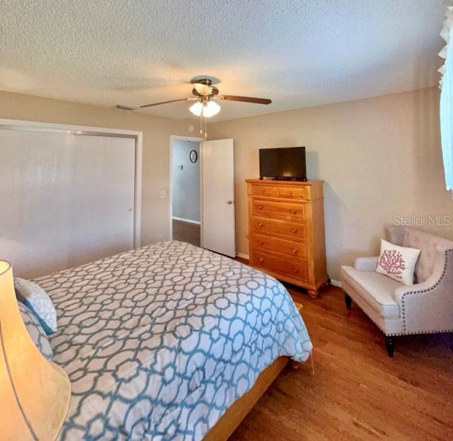 bedroom featuring a textured ceiling, ceiling fan, and hardwood / wood-style flooring