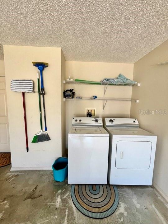 laundry room with washer and clothes dryer, washer hookup, and a textured ceiling