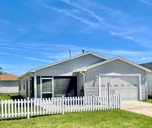 view of front of home with a fenced front yard, a front lawn, driveway, and a garage