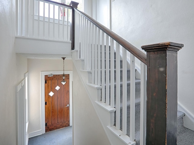 staircase featuring light carpet