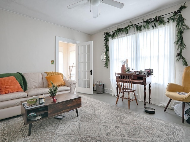 living room with plenty of natural light, french doors, ornamental molding, and ceiling fan