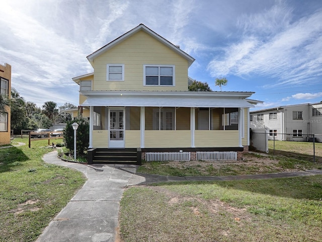 view of front of property featuring covered porch and a front yard