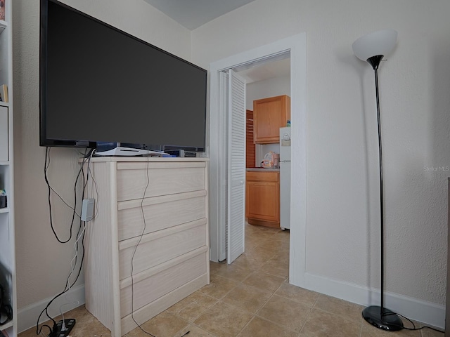 interior space featuring light tile flooring and white refrigerator