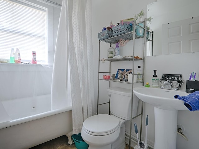 bathroom featuring a healthy amount of sunlight, toilet, and shower / bathtub combination with curtain