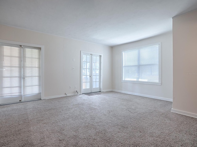 spare room with dark colored carpet and french doors