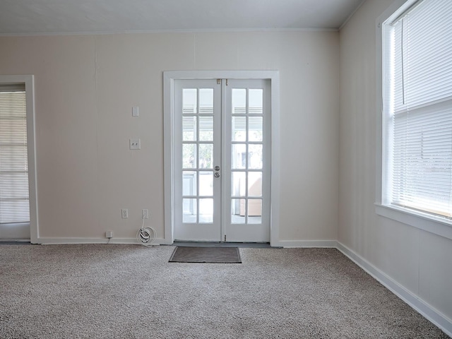 doorway to outside with french doors, ornamental molding, and dark carpet