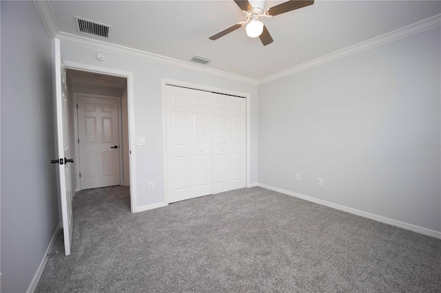 unfurnished bedroom featuring dark carpet, a closet, ornamental molding, and ceiling fan