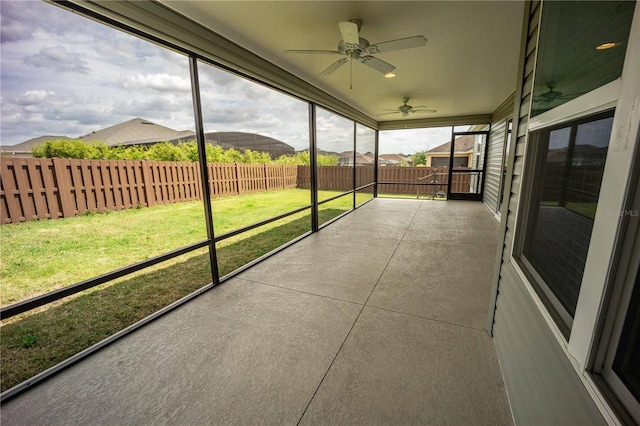 unfurnished sunroom featuring ceiling fan