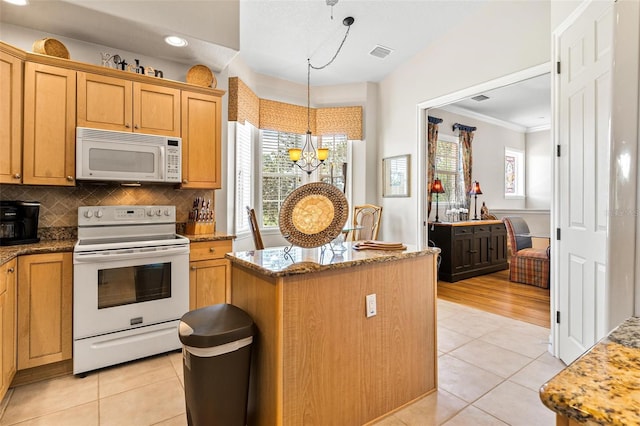 kitchen with tasteful backsplash, crown molding, a center island, light wood-type flooring, and white appliances