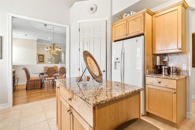 kitchen with backsplash, a notable chandelier, crown molding, light stone countertops, and light tile floors