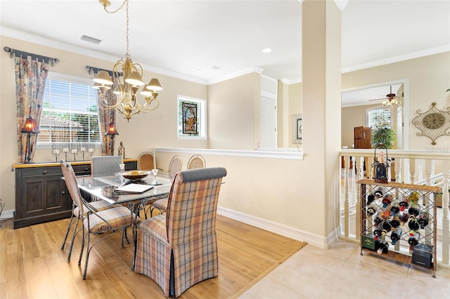 tiled dining area featuring ceiling fan with notable chandelier, ornamental molding, and a healthy amount of sunlight