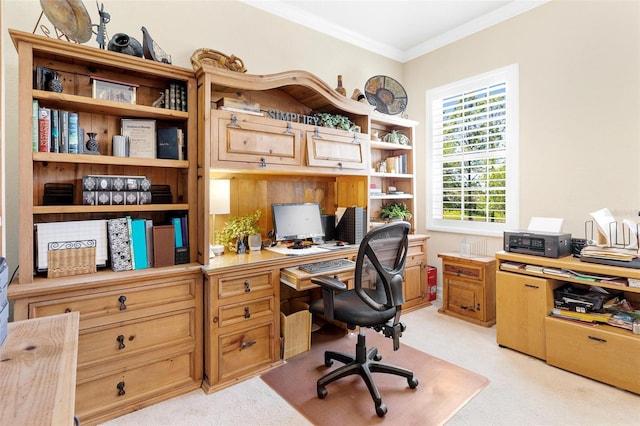 office area with ornamental molding, built in desk, and light colored carpet