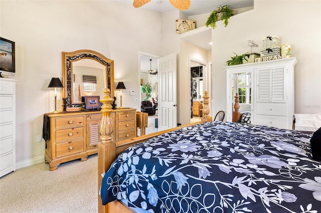 carpeted bedroom with a high ceiling and ceiling fan