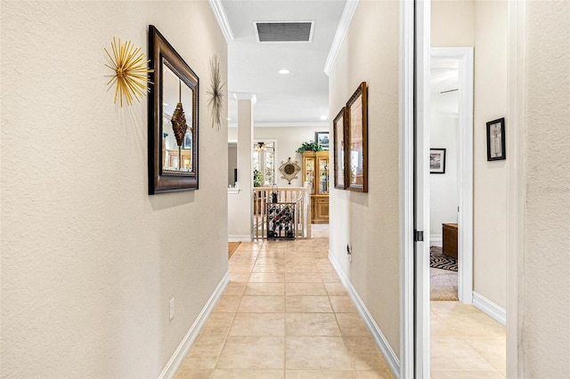 hall with ornamental molding and light tile floors