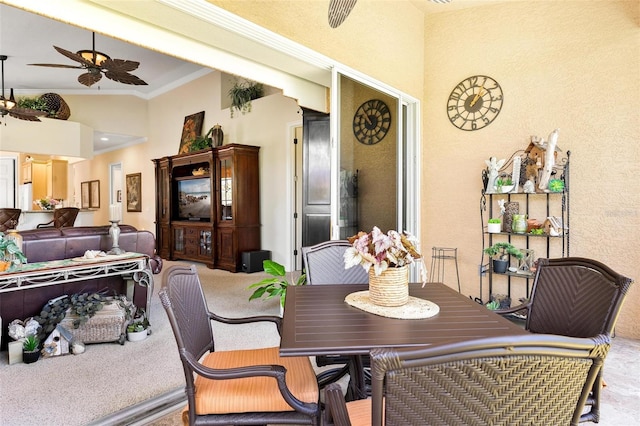 carpeted dining room featuring a towering ceiling and ceiling fan